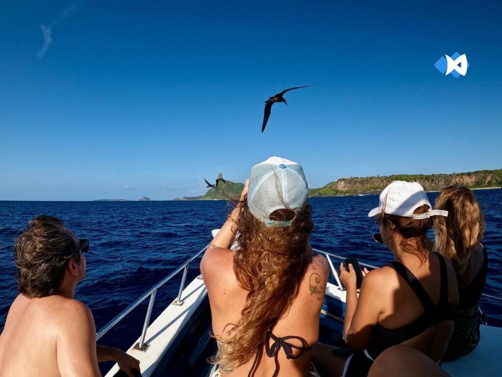 Turistas tirando foto durante passeio de barco em Fernando de Noronha